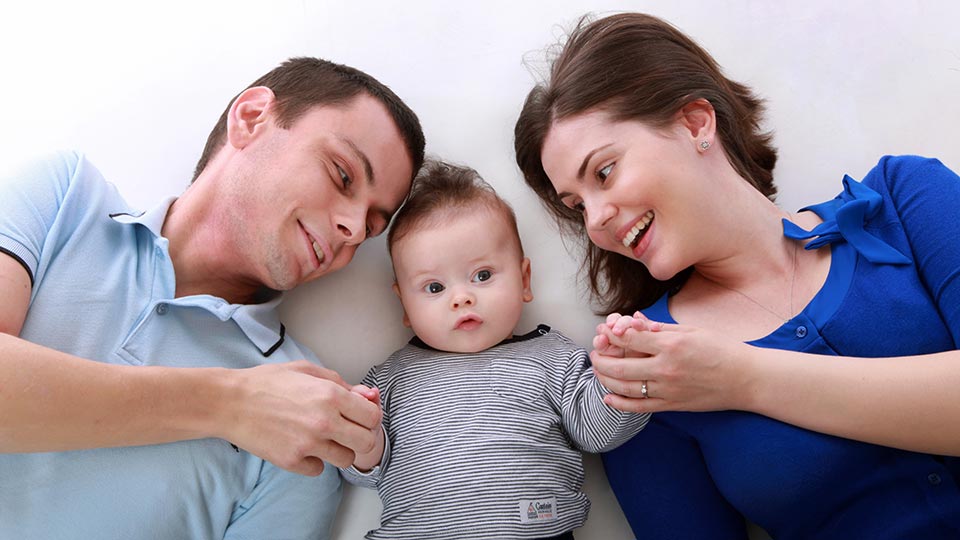 Happy couple playing with baby